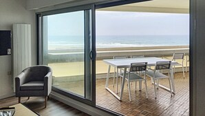 A balcony with a table and chairs overlooking the beach. - Appt 1ère Ligne 2 Terrasses 3 Chambres Accés Direct à la Plage (Canet-en-Roussillon)