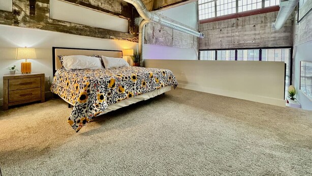 Una camera da letto con un letto, comodini e una grande finestra.