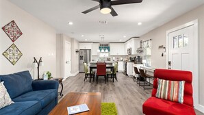 Un salon moderne avec un canapé bleu, un fauteuil rouge et une table basse en bois.