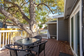 Relax on the patio with a comfortable seating area featuring a wooden deck, round table, and four chairs.