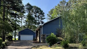 A gravel driveway leading to a blue garage and a stone building with a stone foundation. - The Blue Lagoon on the 18th hole!  Walk to pool, food,  and golf! (Fairfield Bay)