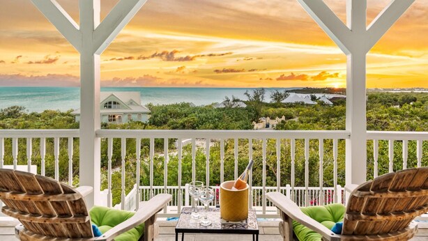 A covered outdoor area with a view of the ocean and a house in the background. - Beautiful Home by Taylor Bay Beach (Providenciales)