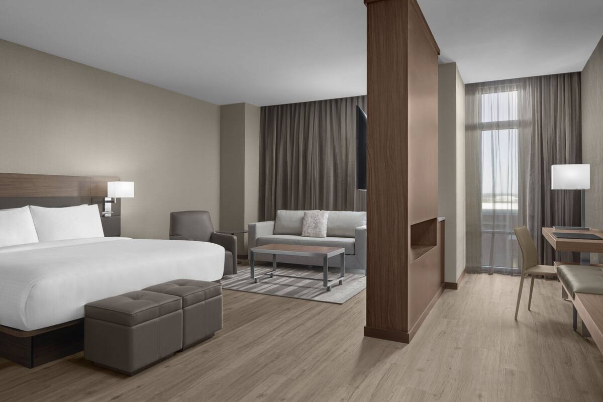 Een moderne hotelkamer met een groot bed, een bank, een bureau en een stoel.