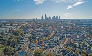 An aerial view of a residential area with houses and a distant city skyline. - AC Hotel Charlotte Ballantyne (Charlotte)