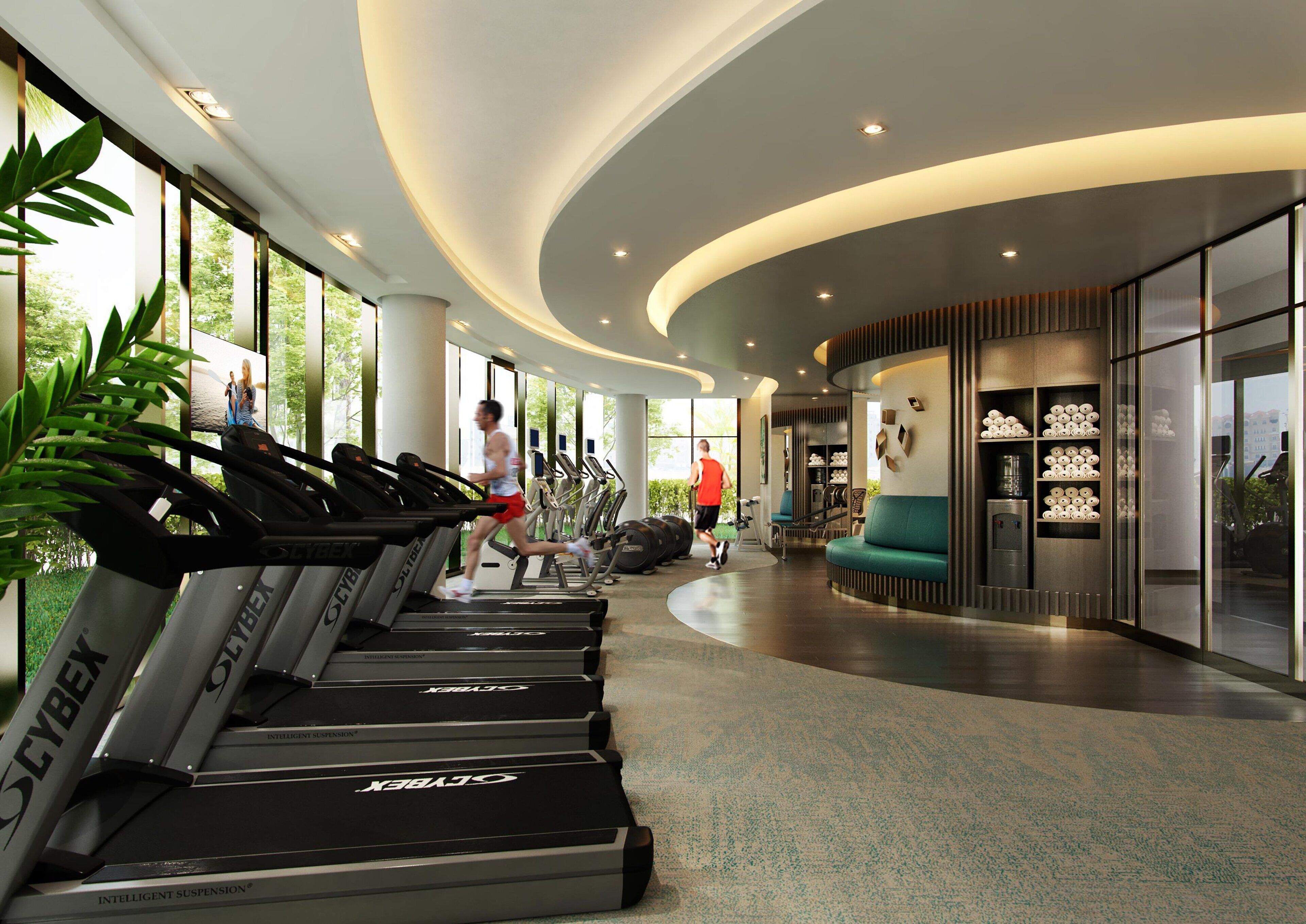 A modern gym with treadmills, a seating area, and large windows.