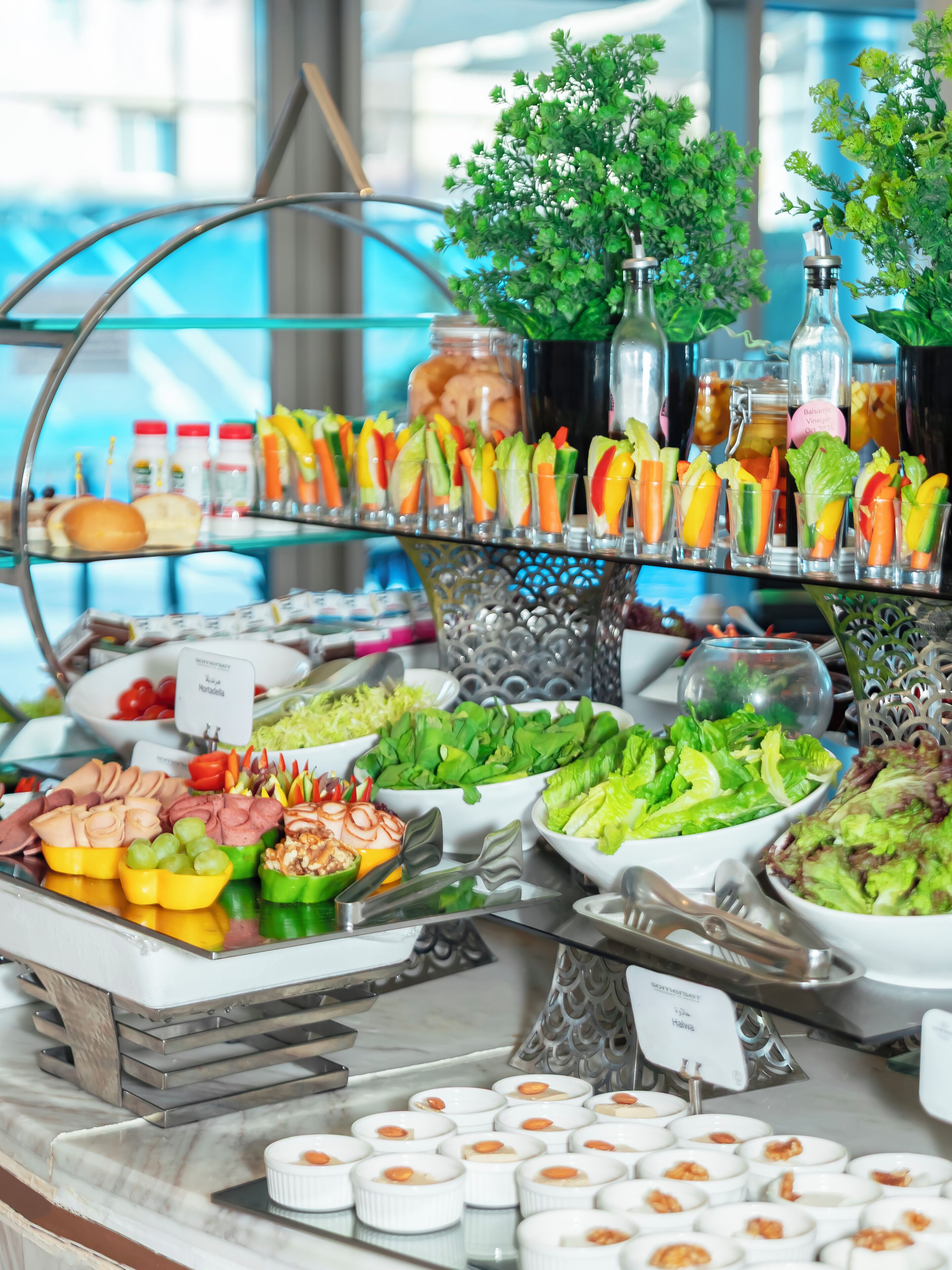 A buffet with various food items and drinks, including salads, meats, and beverages.