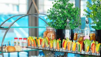 A buffet with various food items and drinks, including salads, meats, and beverages.