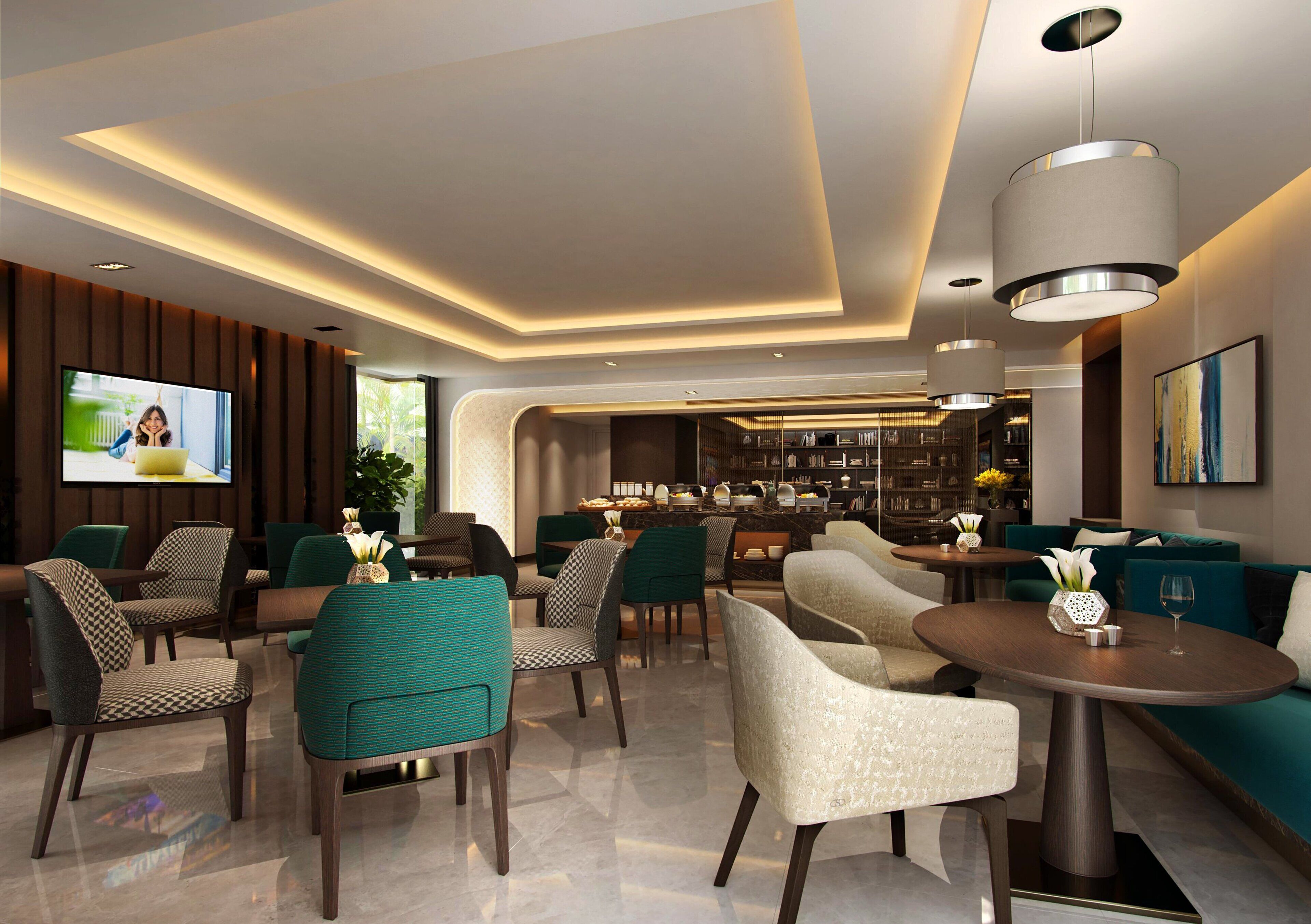 A modern lounge area with seating arrangements, a bar, and a television screen.