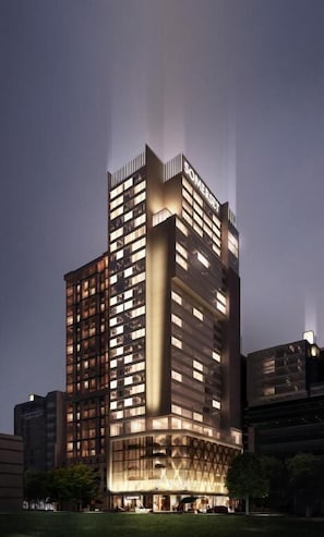 Un hôtel de grande hauteur, avec de nombreux étages, de grandes fenêtres et un hall d’entrée imposant.