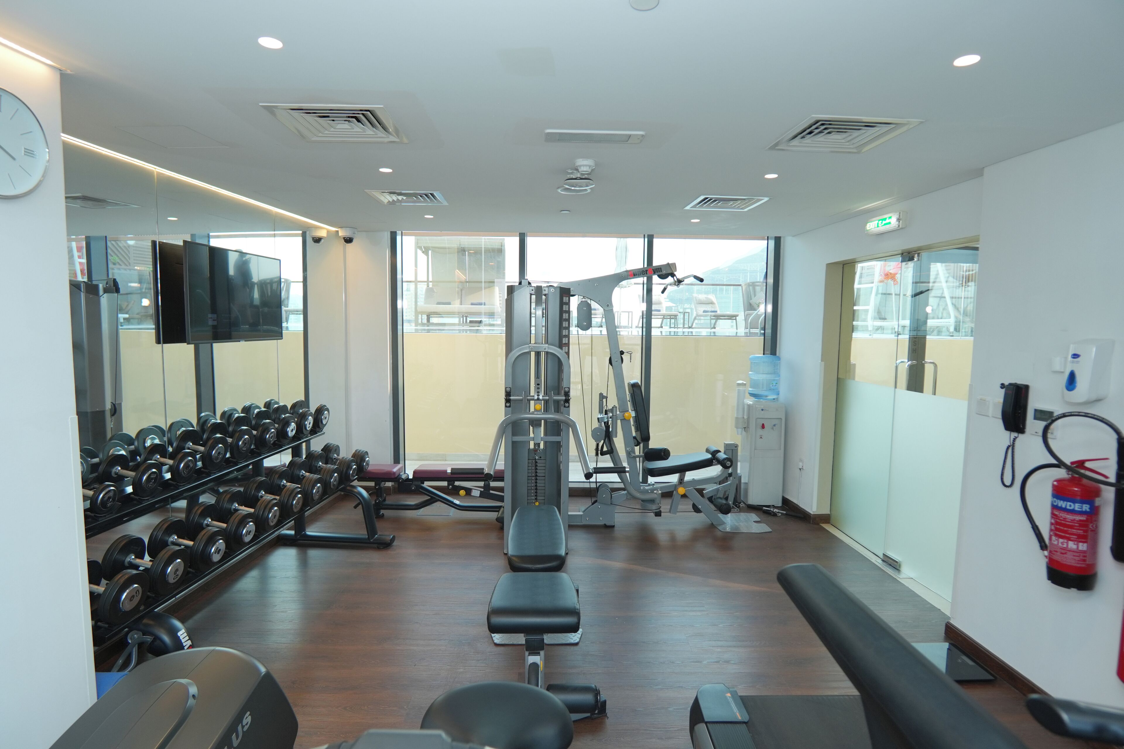 A gym with weightlifting equipment, dumbbells, and exercise machines.