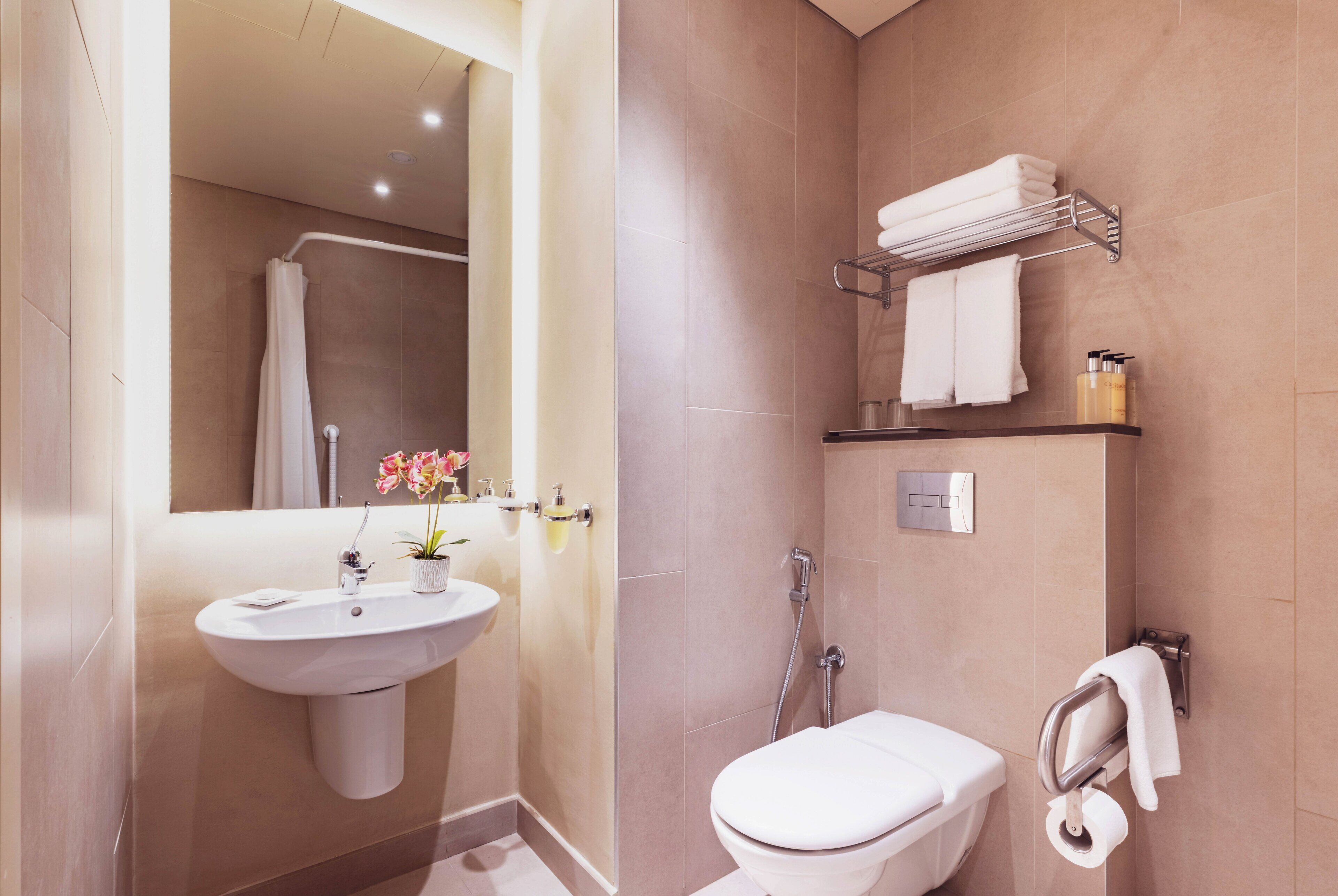 Un baño moderno con lavamanos, inodoro y ducha.