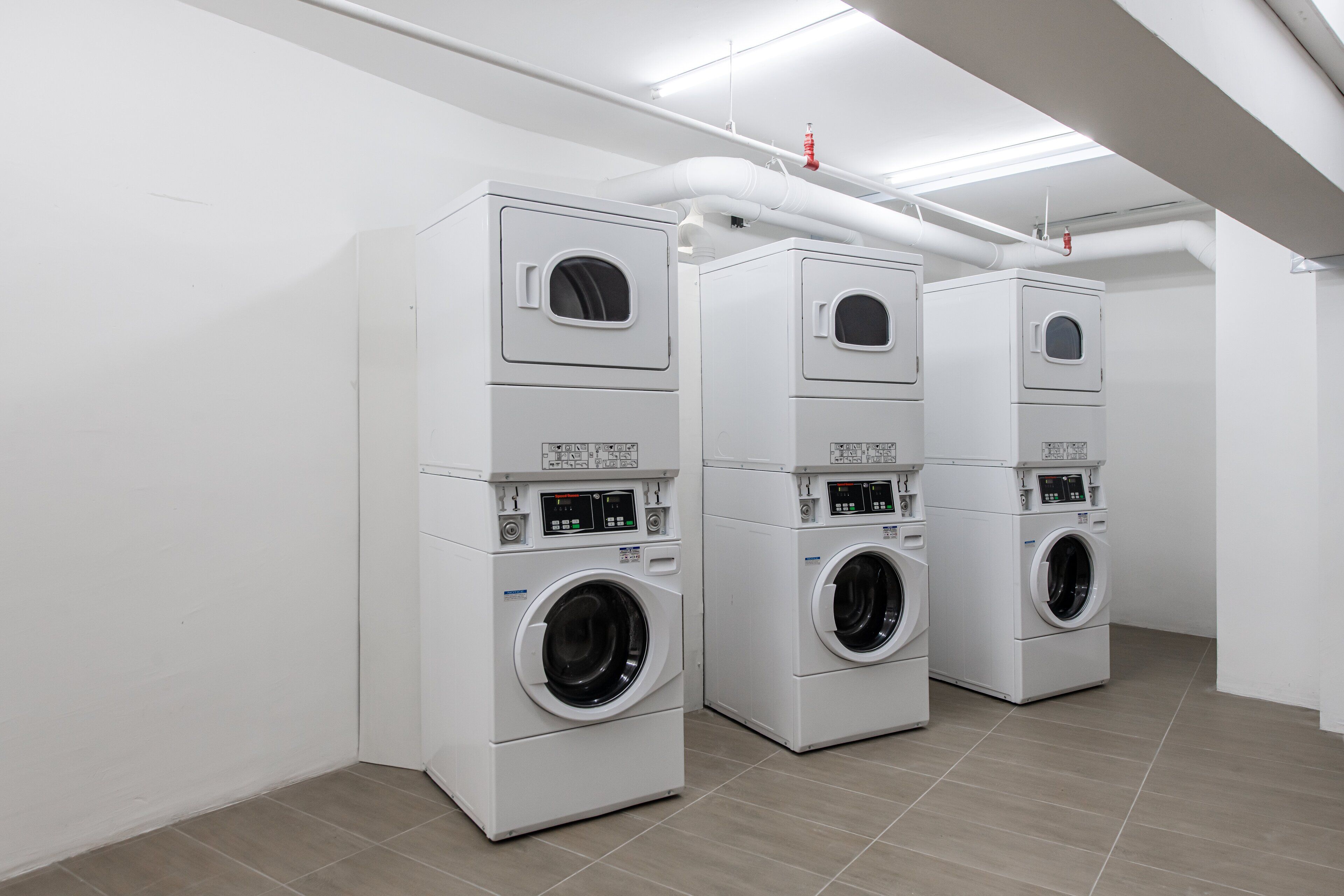 A laundry room with three stacked washing machines.
