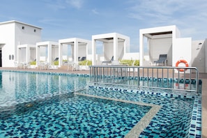 Relax by the pool surrounded by a mosaic tile design and lounge chairs.