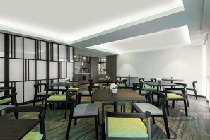 Enjoy meals in this stylish dining area with a central table, dark wood chairs, and a modern ceiling design.