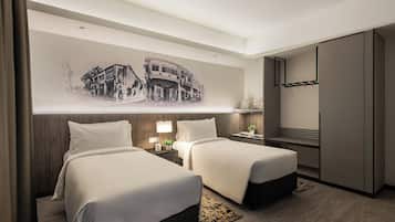 A hotel room with two beds, a wall-mounted TV, a wooden headboard, a nightstand with a lamp, and a large wall mural.