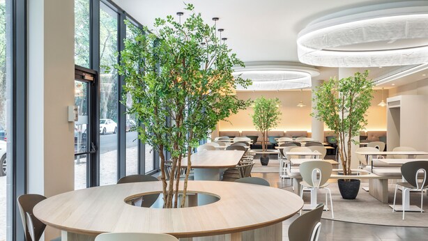 A modern dining area with round tables, chairs, and potted trees. - B&b Hotel Lisboa Montijo (Montijo)