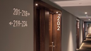 A hotel hallway with directional signs for rooms 201-218 and 219-234, and a door labeled 202. - B&b Hotel Lisboa Montijo (Montijo)
