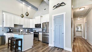 A modern kitchen with white cabinets, stainless steel appliances, and a wooden floor. - Luxury Beach Front Home!!! (Long Beach)