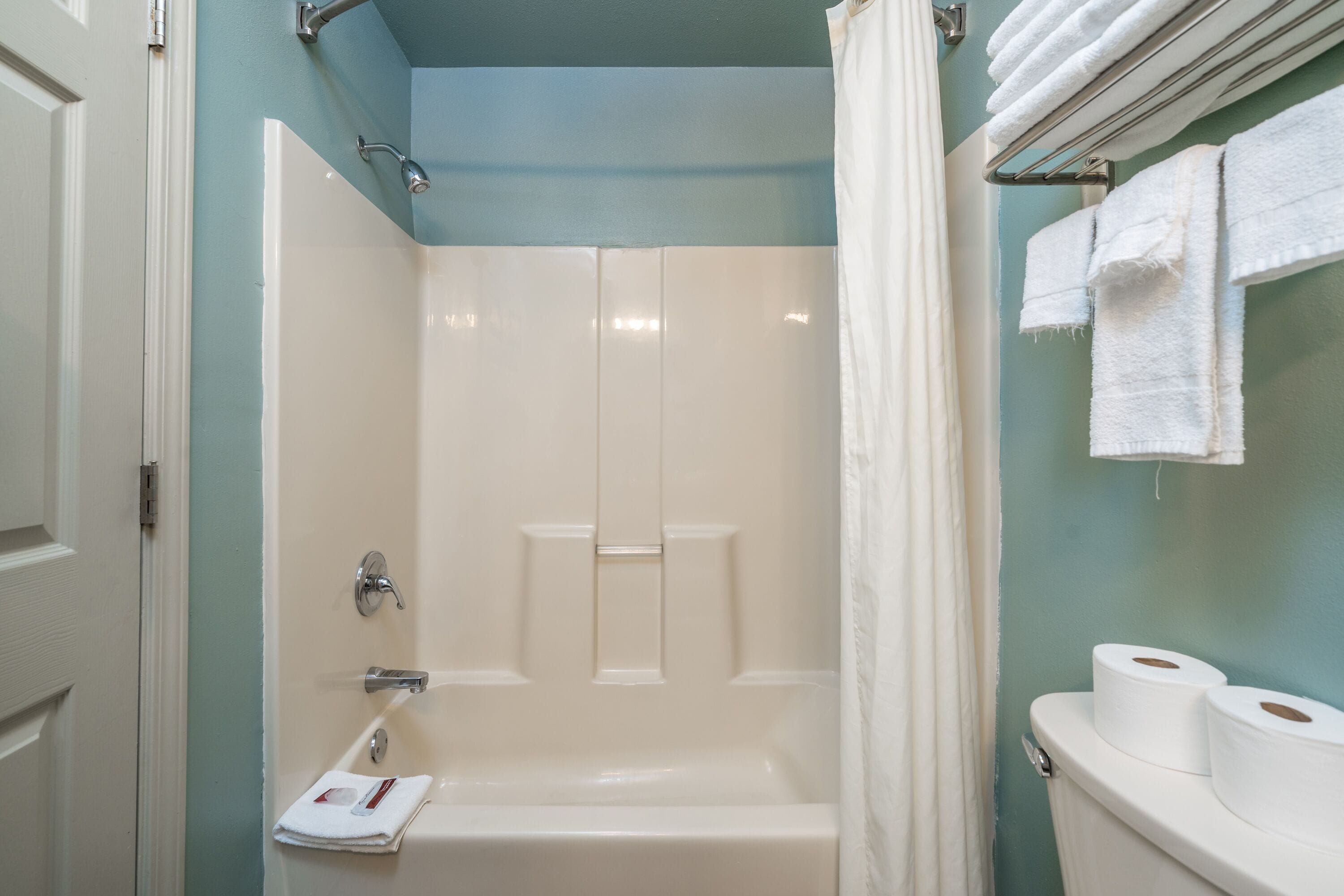 Une salle de bain équipée d’une baignoire, d’une douche, de toilettes et d’un porte-serviettes.