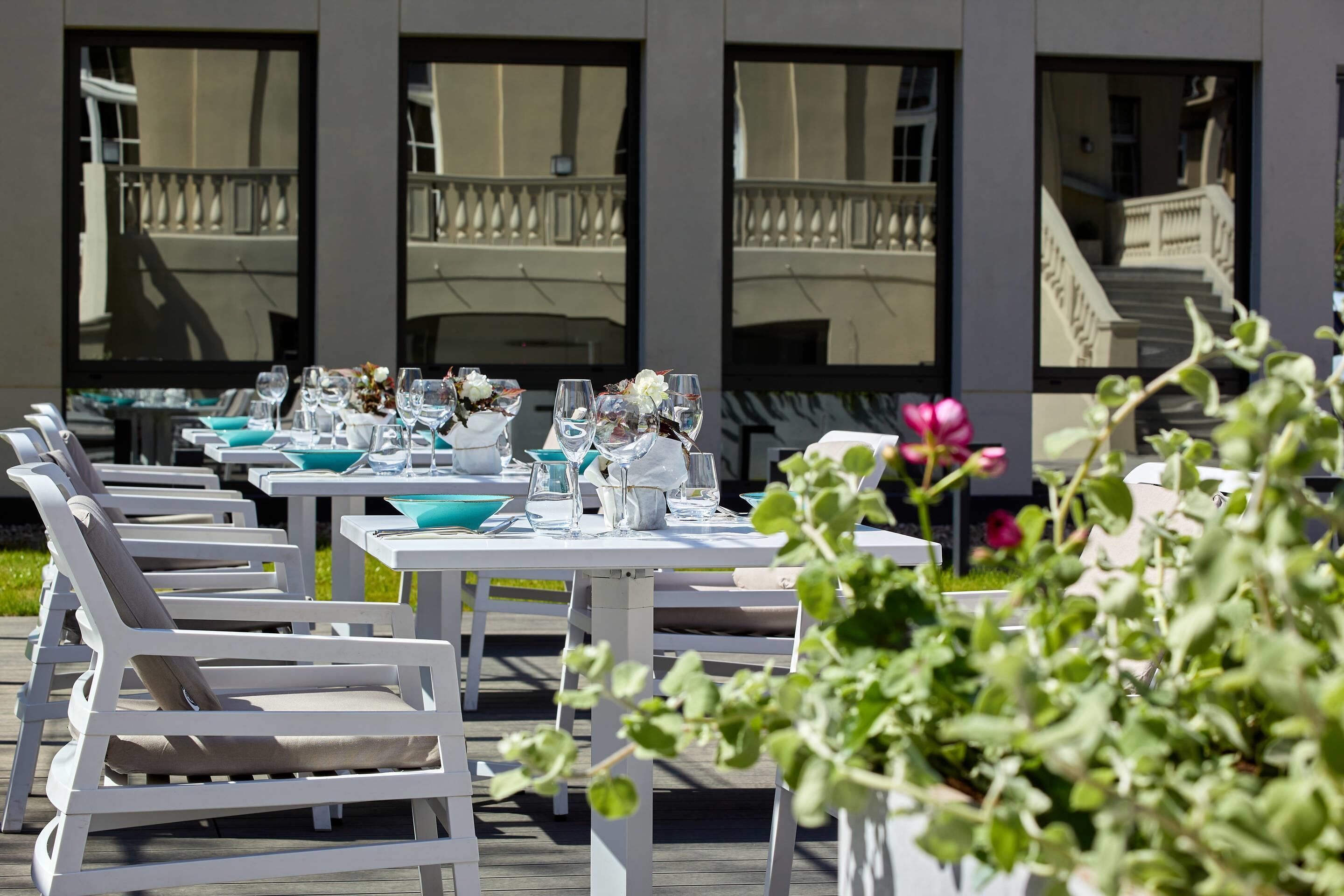 Tables et chaises pour les repas en plein air, chaque ensemble comprenant un verre et un bol.