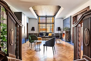 Amplia habitación con piso de madera, chimenea, sofá y dos lámparas.