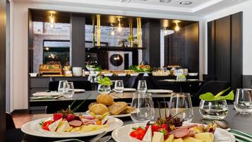 Ein Restaurantinneres mit gedeckten Tischen, Speisen, Besteck und Gläsern.