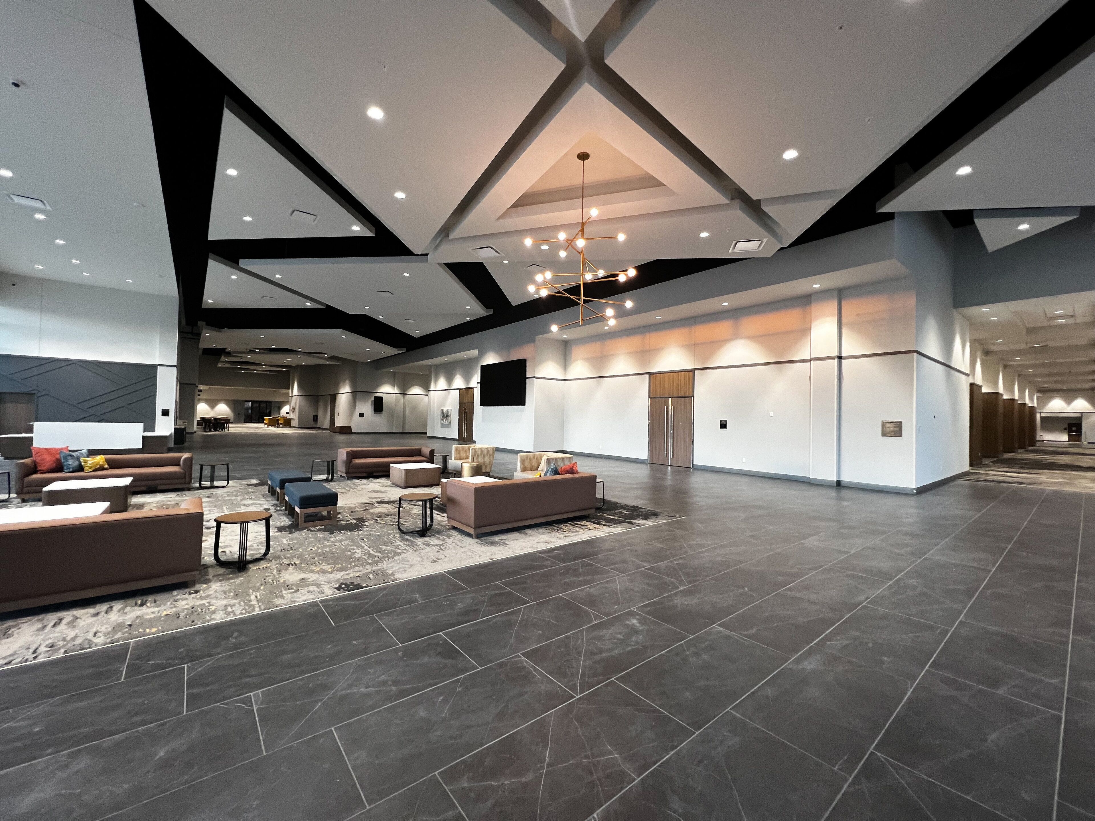 A spacious lobby with modern furnishings, a high ceiling, and a large open area.