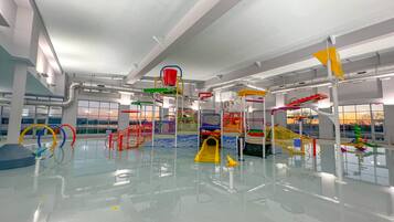 An indoor play area with various play structures and a glass floor.