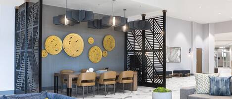 Een modern interieur met een eethoek, banken en een decoratieve wand.