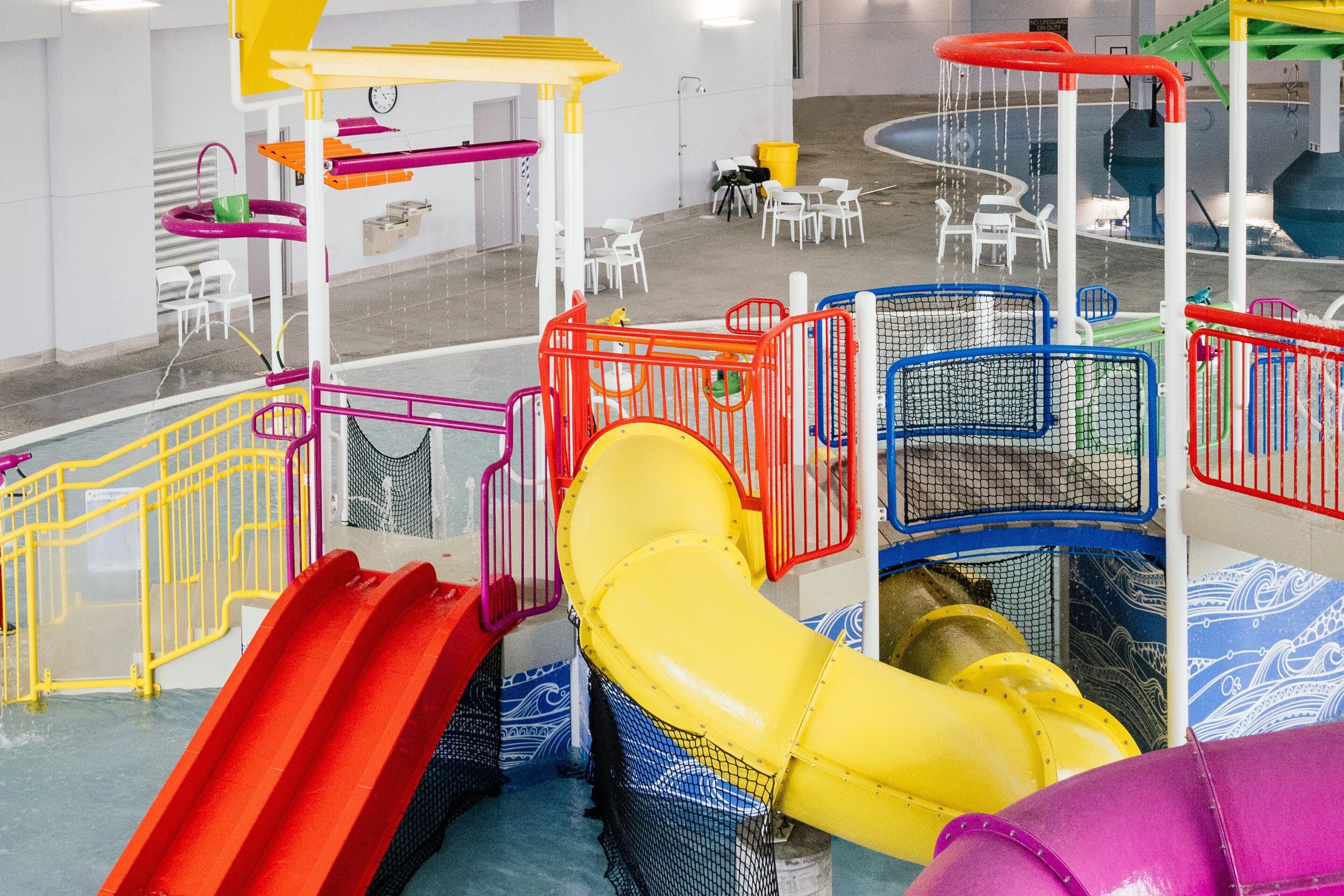 A multi-level indoor play area with slides and climbing structures.