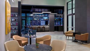 A modern lounge area with seating and a bar. - Courtyard by Marriott Atlanta Midtown (Atlanta)