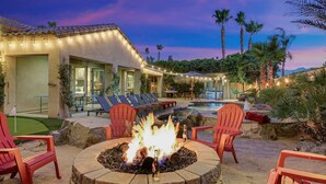 A poolside area with a fire pit, lounge chairs, and a pool. - Tahiti: Walking Distance to Coachella! (Indio)