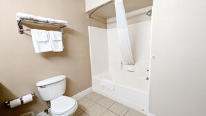 A bathroom with a toilet, a shower, and a towel rack.