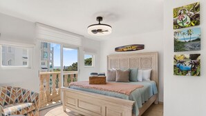 Ein Schlafzimmer mit Bett, Balkon und Blick auf Gebäude.