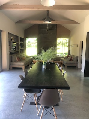 Un comedor amplio con una mesa larga, sillas y una planta en maceta.