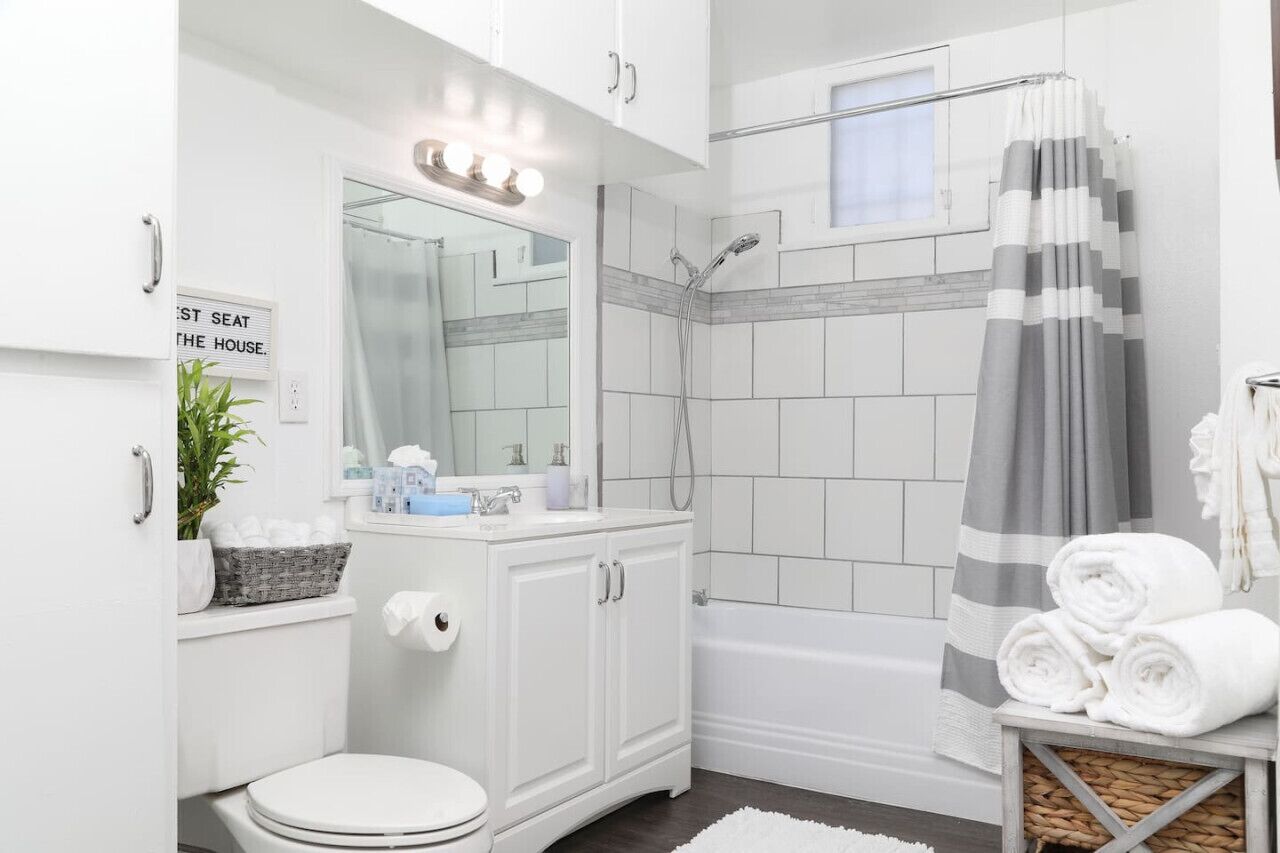 Une salle de bain moderne équipée de toilettes, d’un lavabo, d’un meuble-vasque, d’une douche et d’un porte-serviettes avec des serviettes.