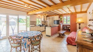 A cozy interior with a dining area, kitchen, and a small seating space. - La Ferme de la Terve (BRUAILLES)