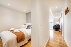 Relax in a serene space with a large bed, bedside table, and comfortable seating area.