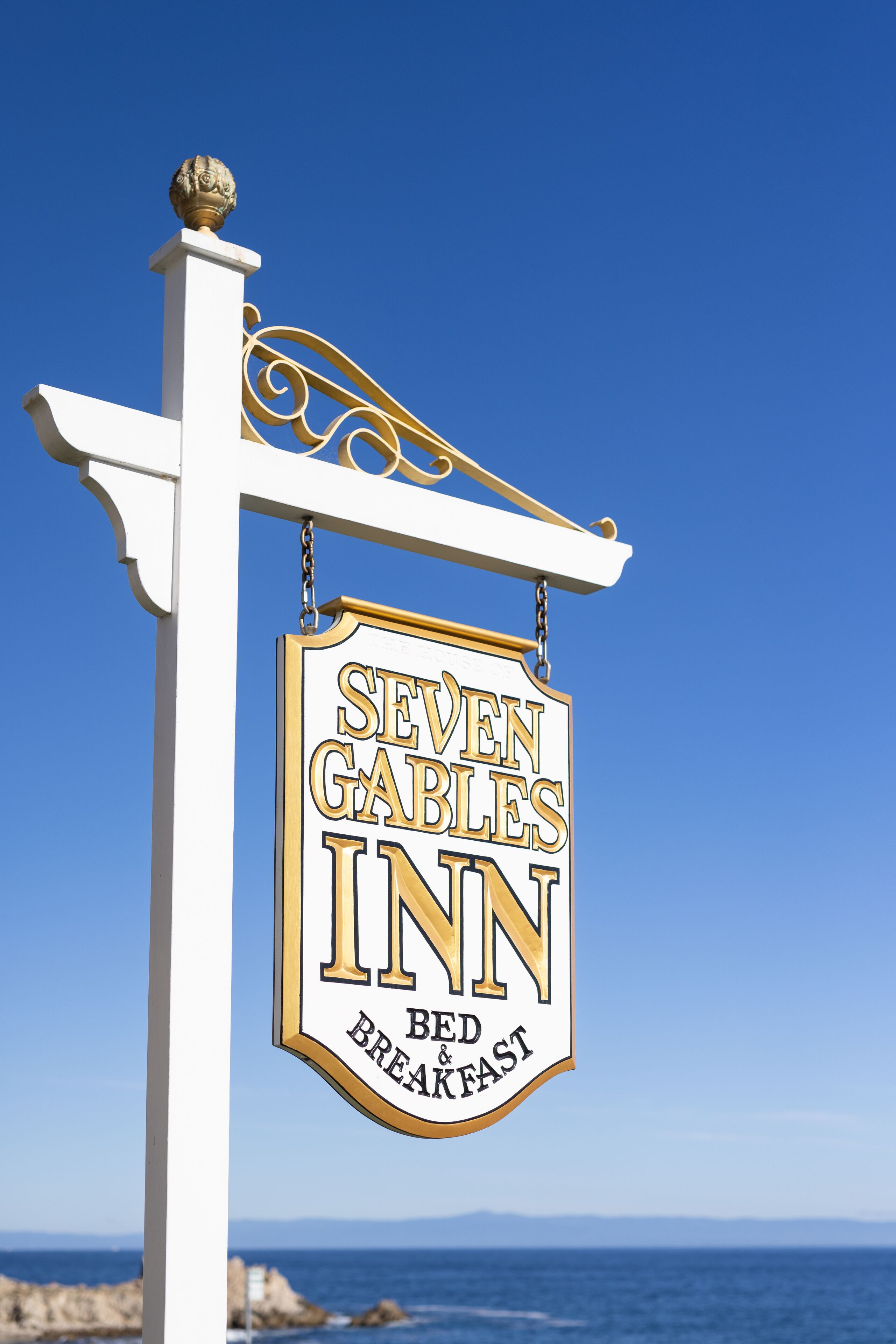 En skylt för ”Seven Gables Inn”, med havet tydligt synligt i bakgrunden.