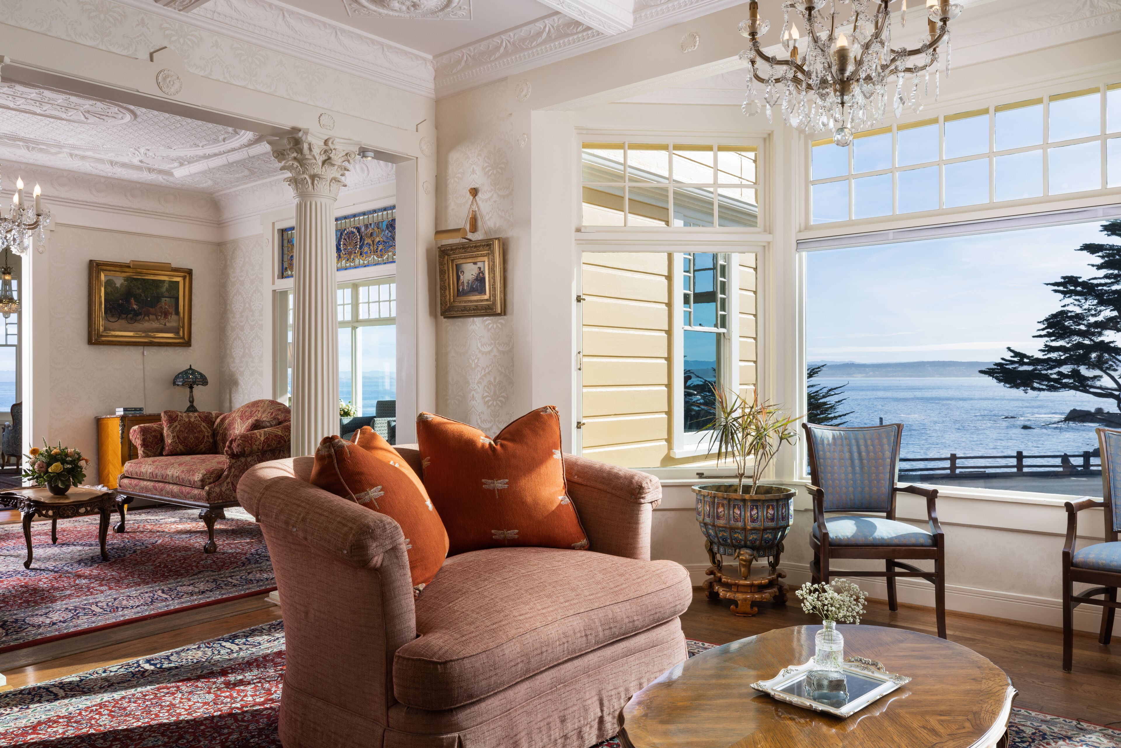 A spacious living room with a large window overlooking a scenic view, elegant furniture, and decorative elements.