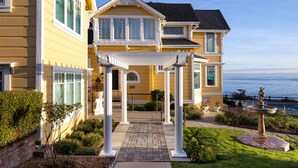 A two-story house with a covered porch, a fountain, and a view of the ocean. - Seven Gables Inn on Monterey Bay, A Kirkwood Collection Property (Pacific Grove)