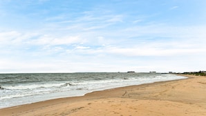 A beach with a clear sky and calm sea.