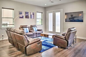 A modern living room with leather recliners, a coffee table, and artwork on the walls.