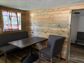 Cozy retreat with a simple layout, featuring a comfortable seating area and a door leading to additional space.