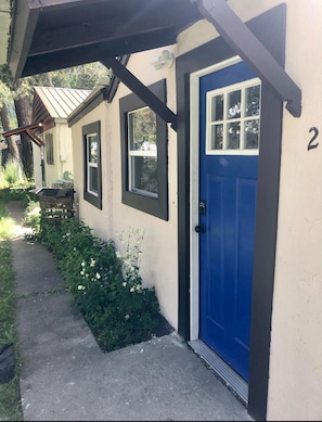 Unit 2 features a cozy porch and a small garden area.