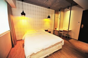 A neatly made bed with a headboard, a desk with a chair, and a mirror on the wall. - Ezbookers Fuxing B (Taipei)