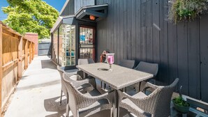 An outdoor patio with wicker furniture, a table, and chairs. - Fully stocked new apt, work from home + Free Parking! (Denver)