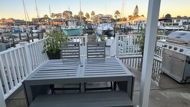 A covered outdoor seating area with a view of a marina and boats. - Waterfront Home in Gulf Harbors with Deepwater Access to Gulf with No Bridges (New Port Richey)