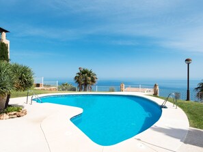 Ein gewölbter Pool mit freiem Blick auf den Ozean im Hintergrund.