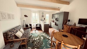 A cozy living room with a sofa, a dining table, and a kitchen area with modern appliances. - Mazet for 6 people in a domain with pool and tennis court in Cogolin (COGOLIN)